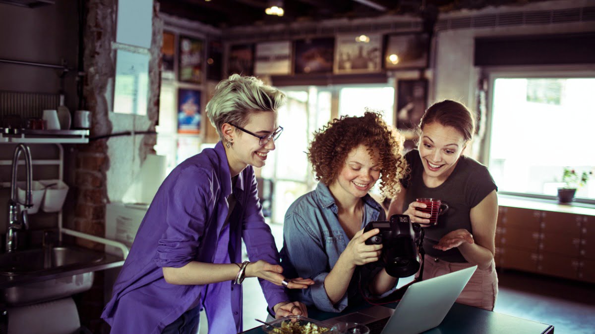 three women looking at photos on camera