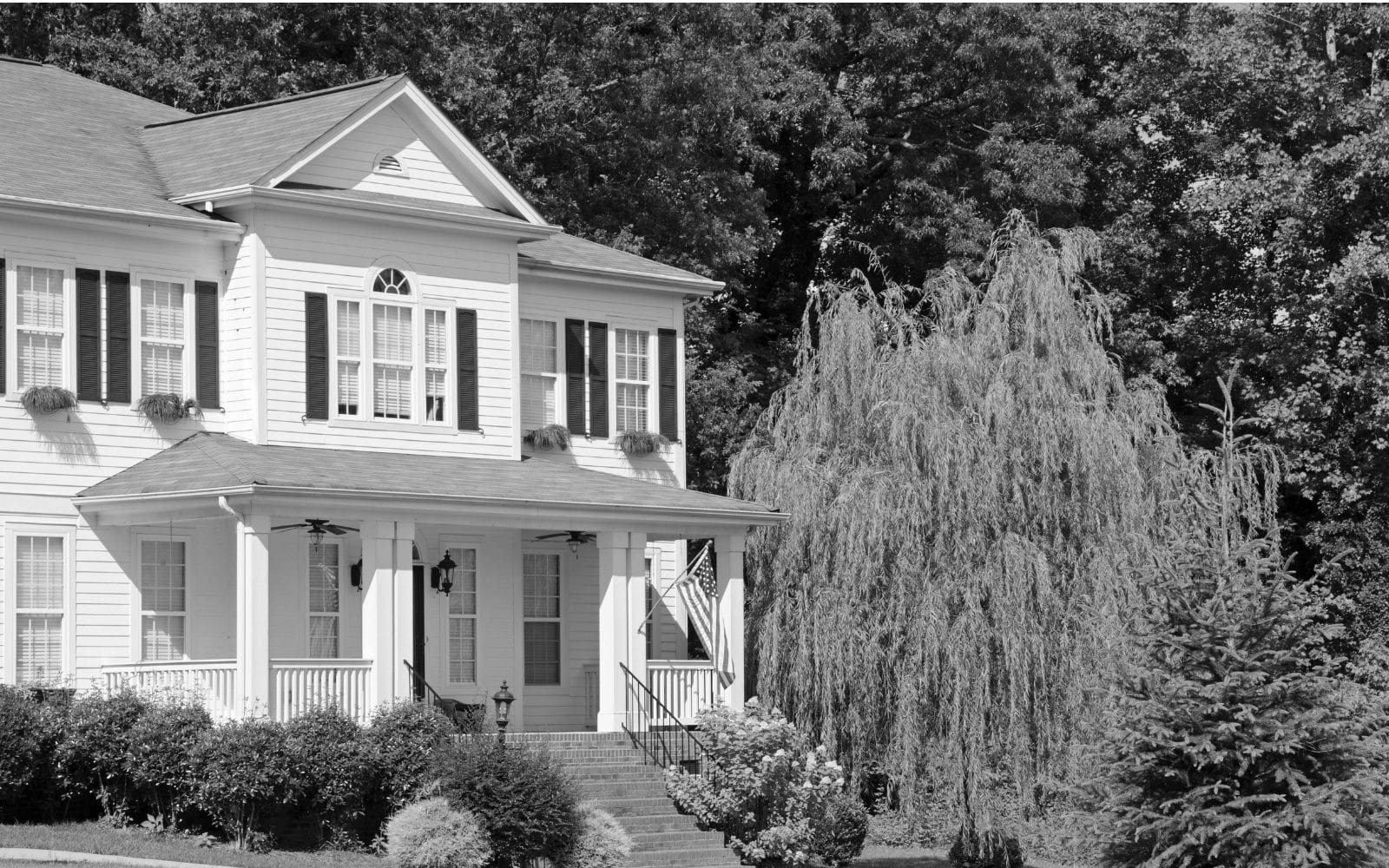 White two-story suburban rental house with manicured lawn