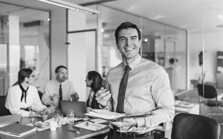 Businessman in Office with Team