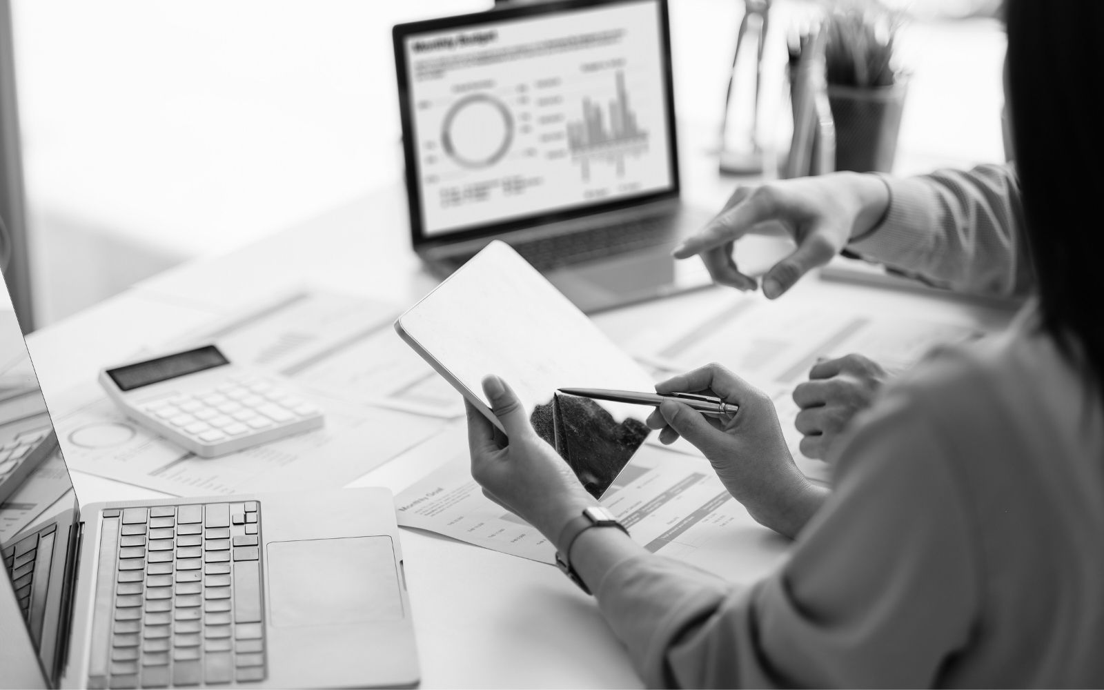 Professionals reviewing house rental data and real estate reports on digital devices.