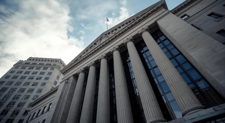 A low-angle view of a large U.S. federal courthouse with stone columns and a cloudy sky, symbolising the legal setting of the Compass and Zillow antitrust case.