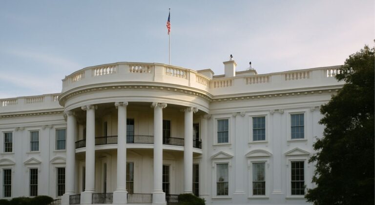 Editorial photograph of the White House East Wing exterior at sunrise, showing neoclassical architecture and columned portico, with soft natural light and no people present.