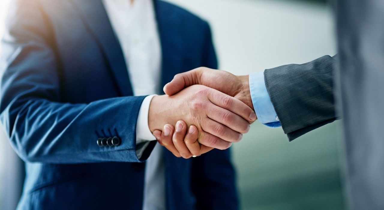 Business professionals shaking hands to represent a strategic data partnership